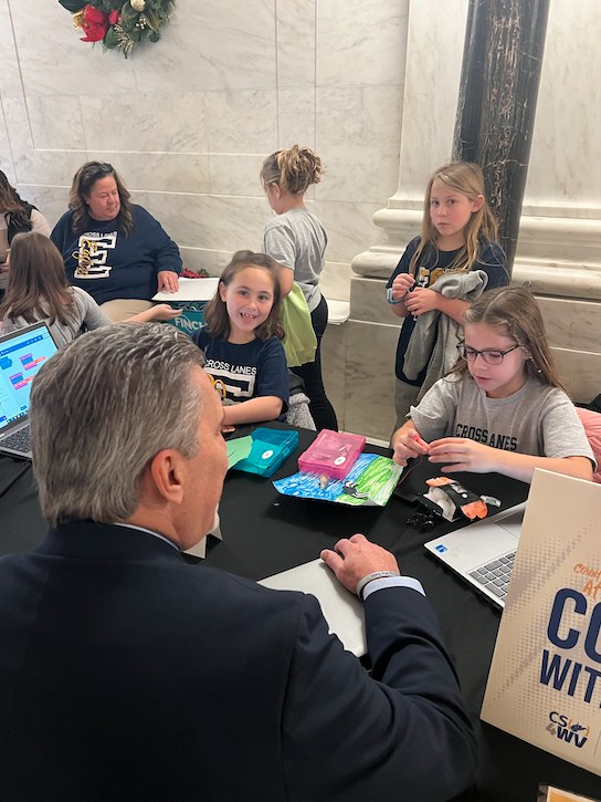 Adult and students coding together