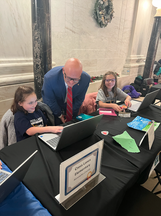 Student walking a legislator through their project
