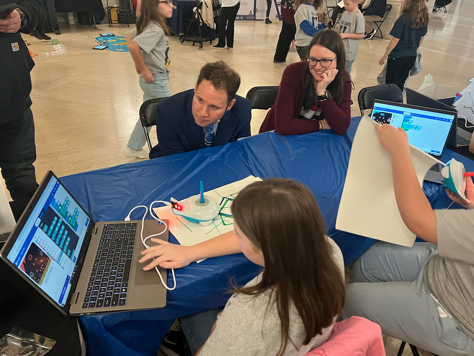 Teacher helping student with laptop