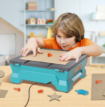Boy using a Swift saw on cardboard