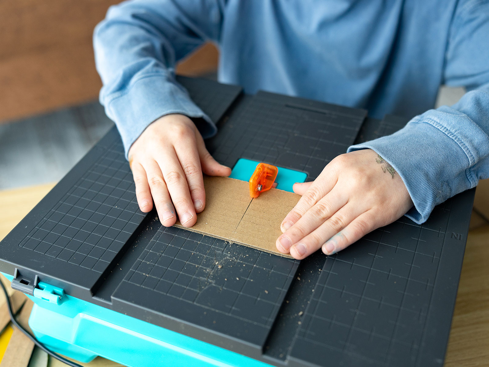 Child safely cutting cardboard with the Swift saw